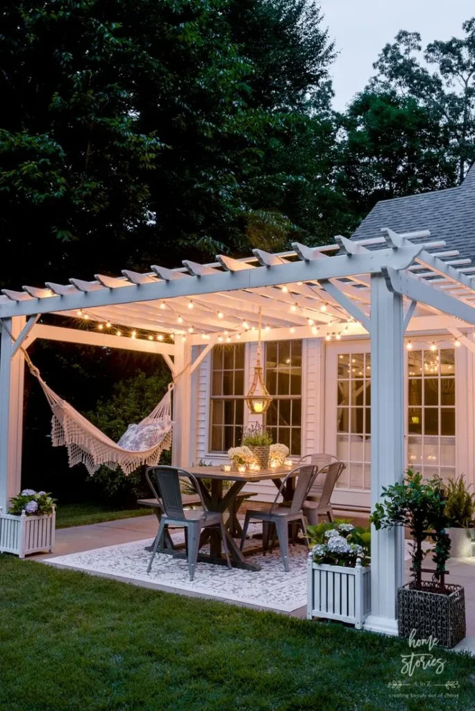 a beautiful all white pergola attached to the backyard of the house in twilight hours