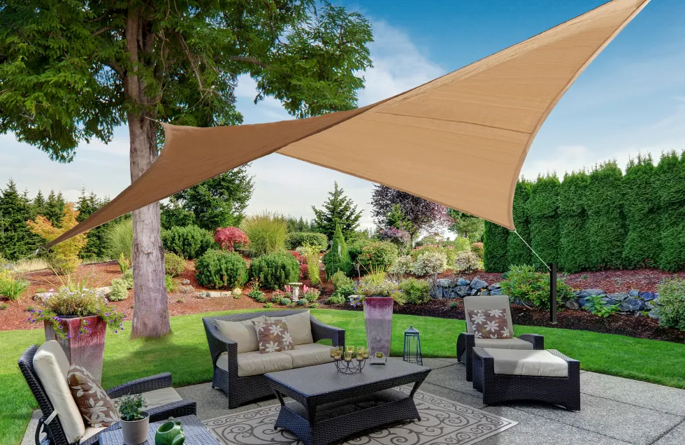 Square tan shade sail in hypar providing shade to a stone back patio